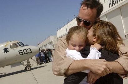 Lt. Dan-O McShane hugs his daughter, Samantha McShane, 3, and wife, Larissa McShane, as the Black Eagles of Carrier Airborne Early Warning Squadron 113 arrive home to Naval Base Ventura County at Point Mugu, Calif.